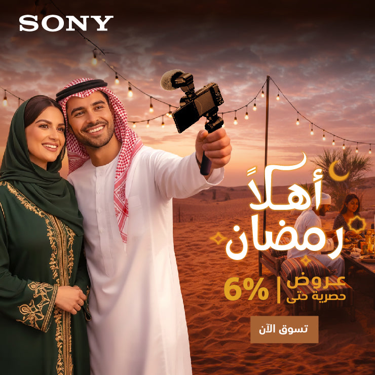 Couple in traditional attire holding a camera in a desert setting with promotional text overlay.