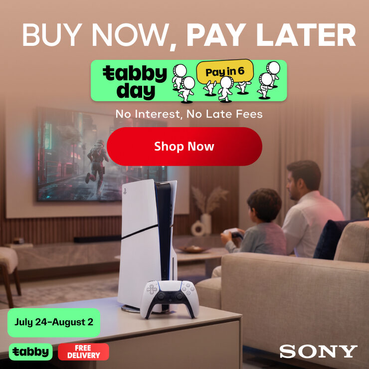 Sony PlayStation 5 console and controller displayed in a living room setting, with a family sitting on a couch watching a game on the TV. Promotional text includes 'BUY NOW, PAY LATER,' 'tabby day,' 'Pay in 6,' 'Shop Now,' 'July 24-August 2,' and 'SONY'.